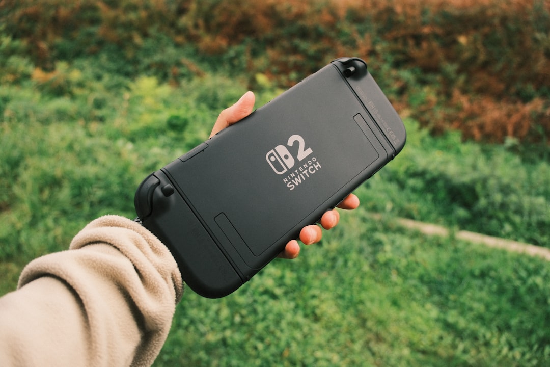 hand-holding-a-black-nintendo-switch-lite-outdoors-6q0usb65cv4